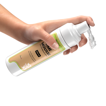 Esthetician hand dispensing Pre-Wax Lime Mousse before a waxing service